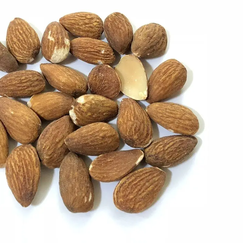 Almendras tostadas con sal sobre fondo blanco