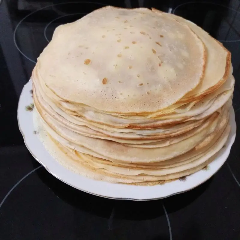Pila de blinis, tortitas finas, sobre un plato blanco