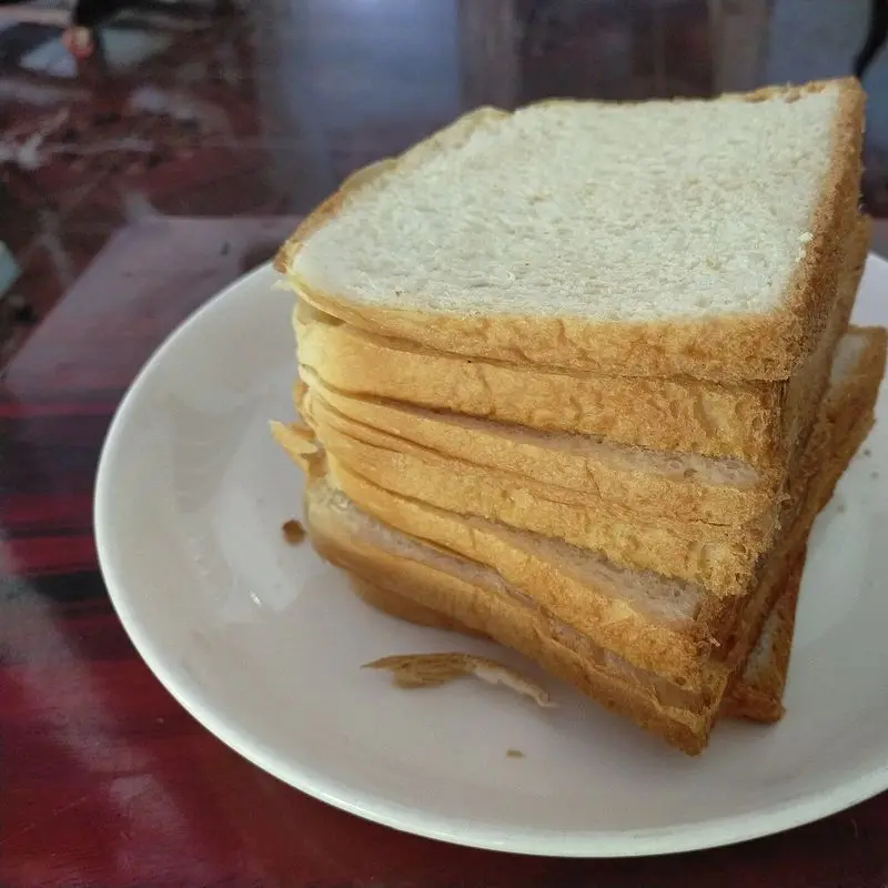 Pila de rebanadas de pan de molde blanco sobre un plato blanco