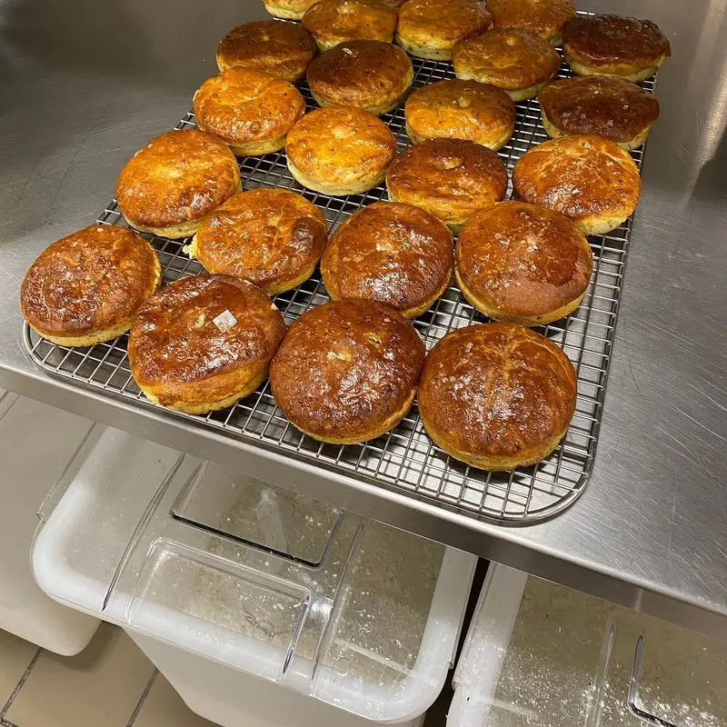 Bollos de brioche dorados recién horneados sobre una rejilla metálica