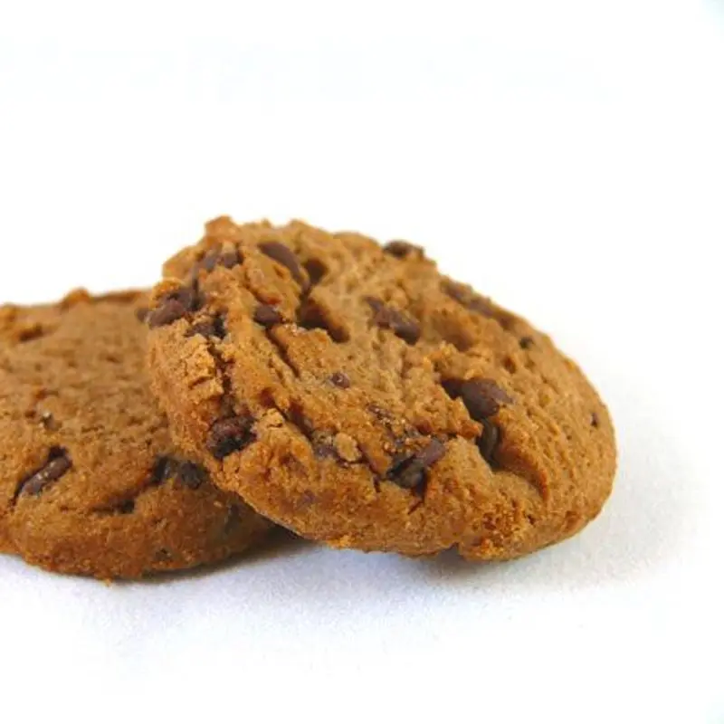Dos galletas de mantequilla con pepitas de chocolate sobre fondo blanco