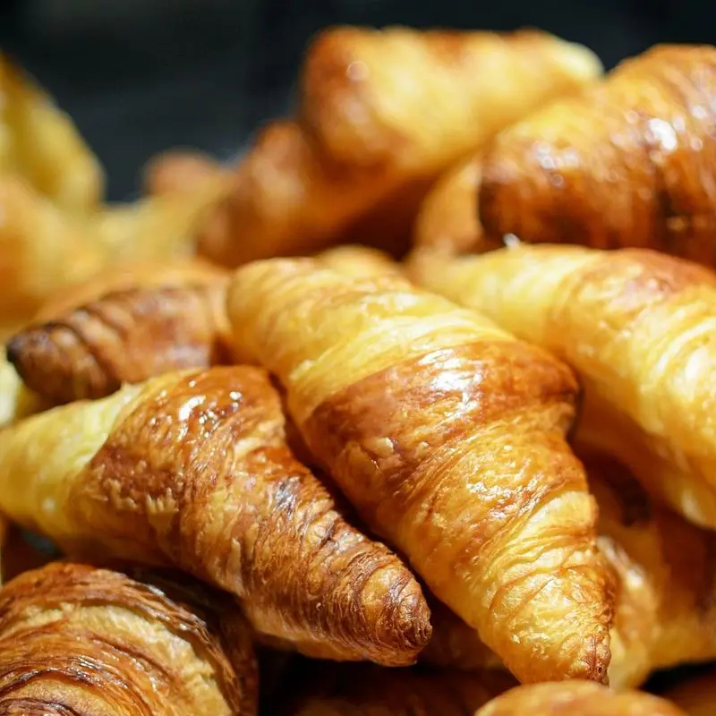Montón de croissants de mantequilla dorados recién horneados