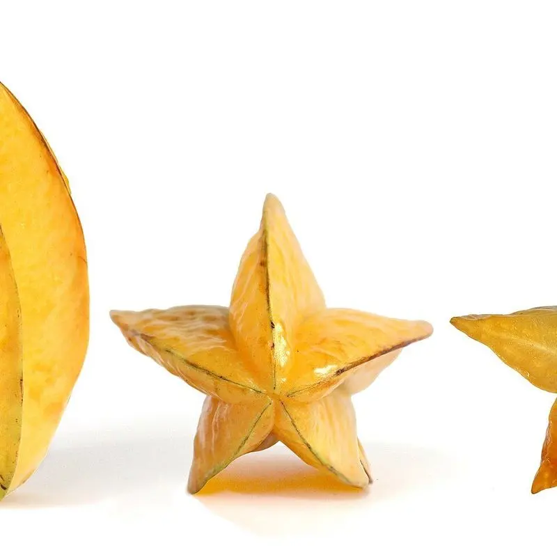 Carambolas amarillas, una cortada en forma de estrella sobre fondo blanco