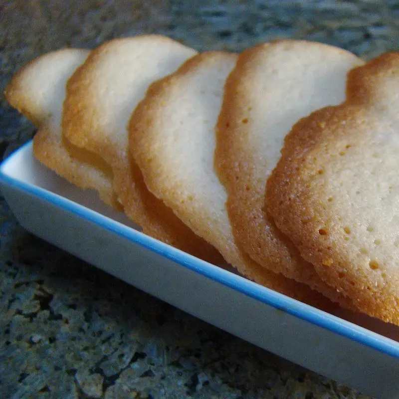 Lenguas de gato, galletas finas y alargadas, apiladas en una fuente blanca