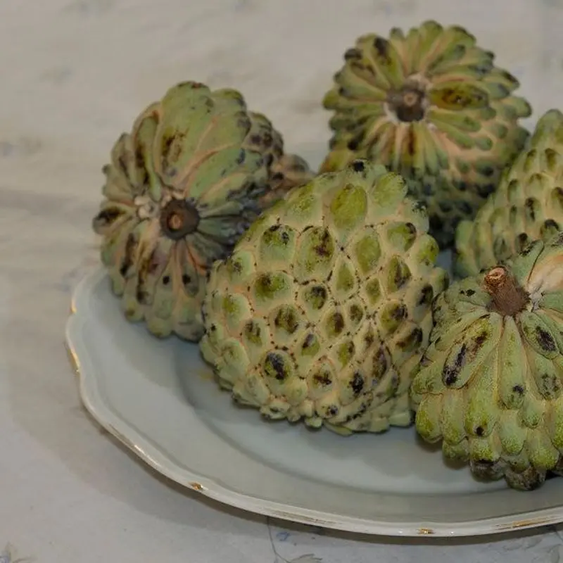 Chirimoyas enteras sobre un plato blanco