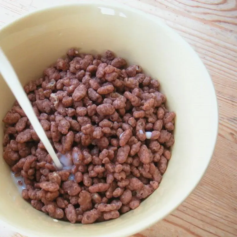 Cuenco claro de cereales de arroz con chocolate con leche vertida