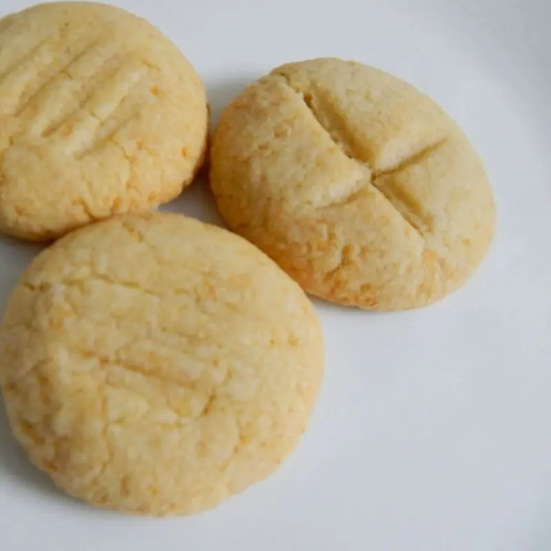 Tres galletas redondas de coco de color claro sobre un plato blanco