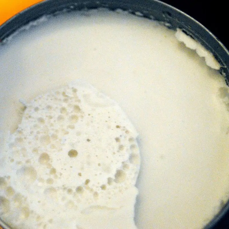 Crema de coco espesa y blanca en un cazo oscuro