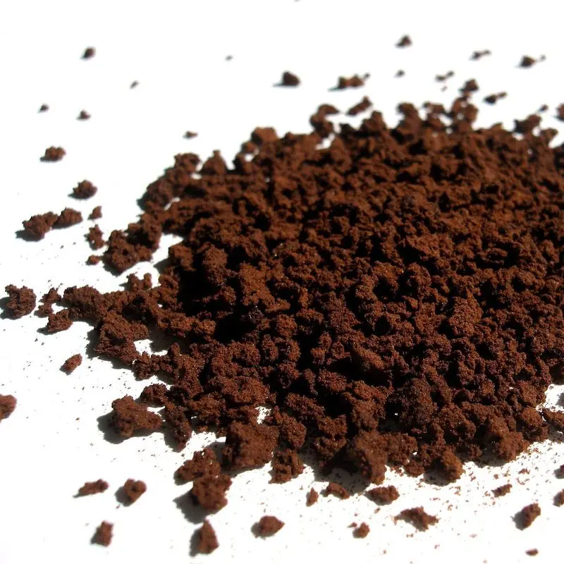 Montón de gránulos de café soluble sobre fondo blanco