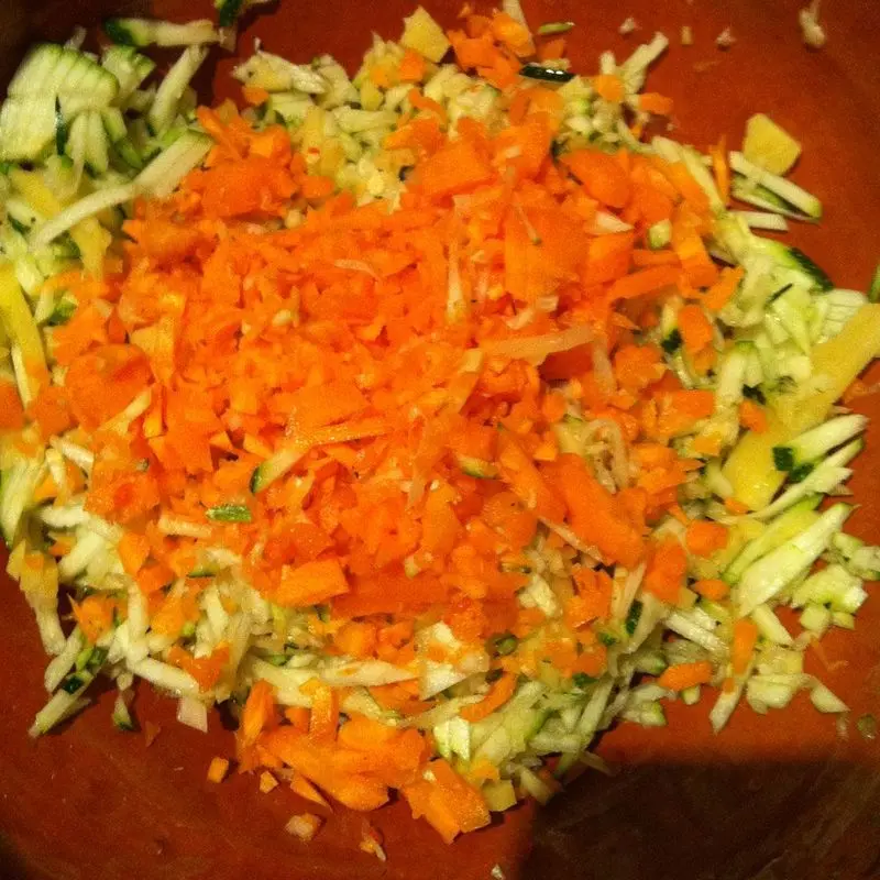 Verduras crudas troceadas en dados pequeños: zanahoria naranja y calabacín verde