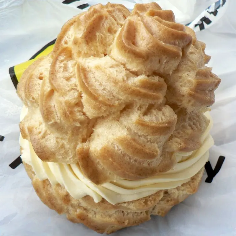 Lionesa de masa choux dorada abierta y rellena de crema