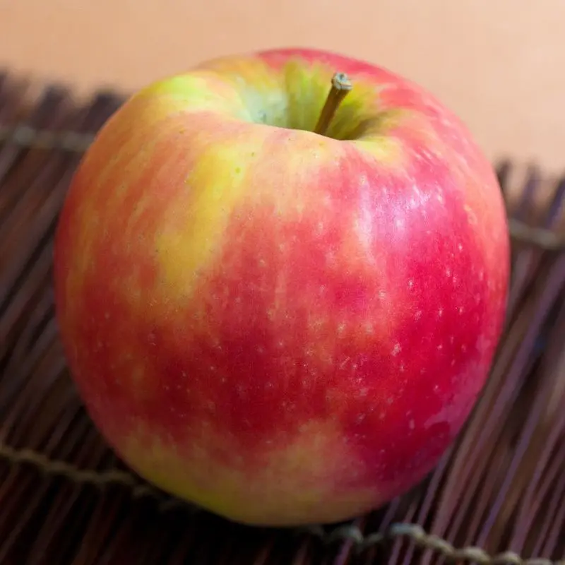 Primer plano de una manzana rosada rojiza y amarilla