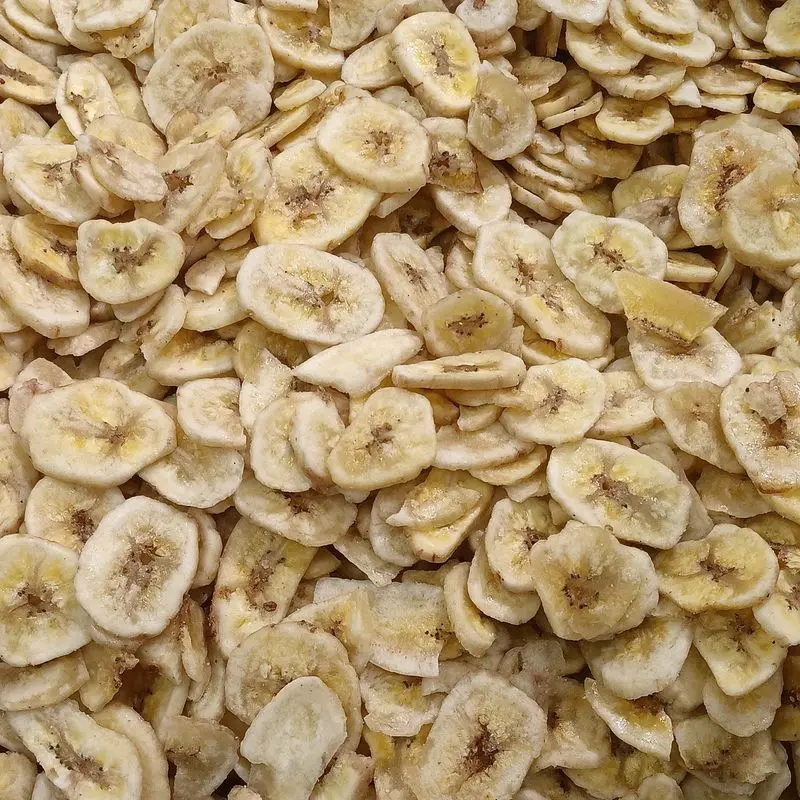 Rodajas de plátano deshidratado amontonadas, de color crema