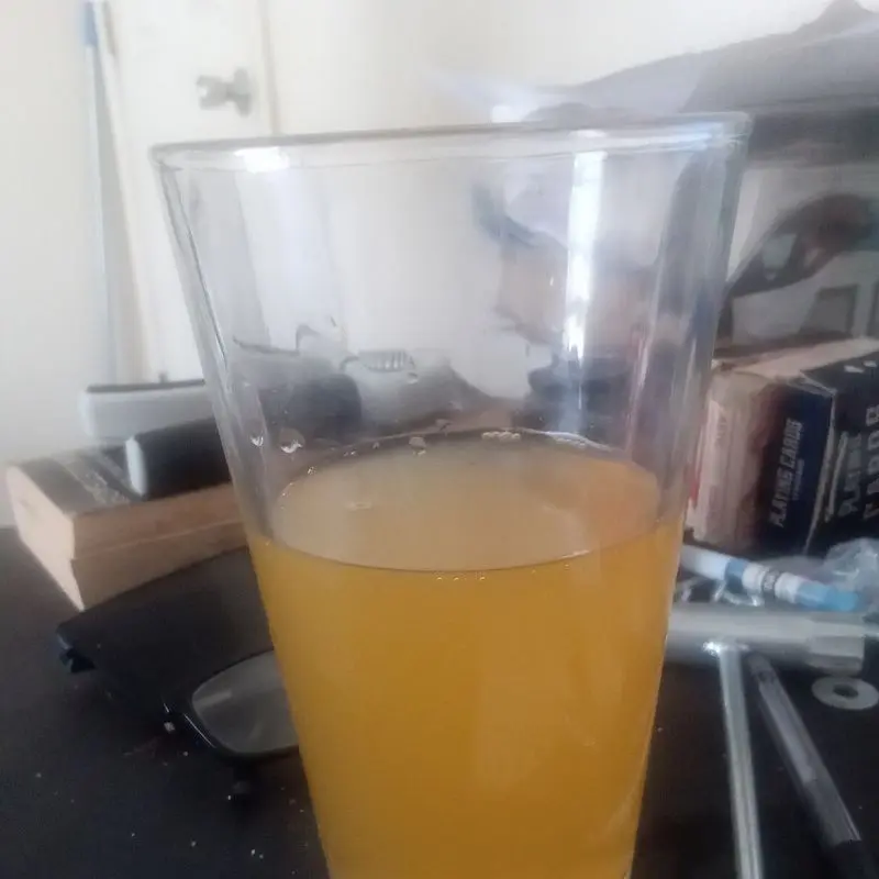 Vaso de bebida energética de color naranja sobre una mesa