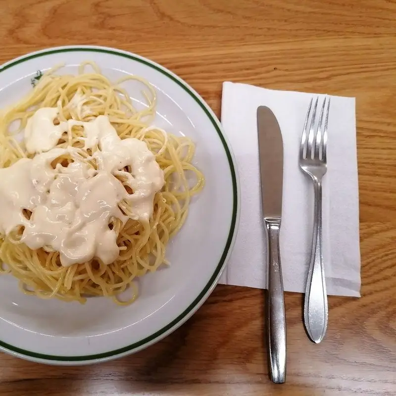 Plato de espaguetis con salsa cremosa de queso por encima