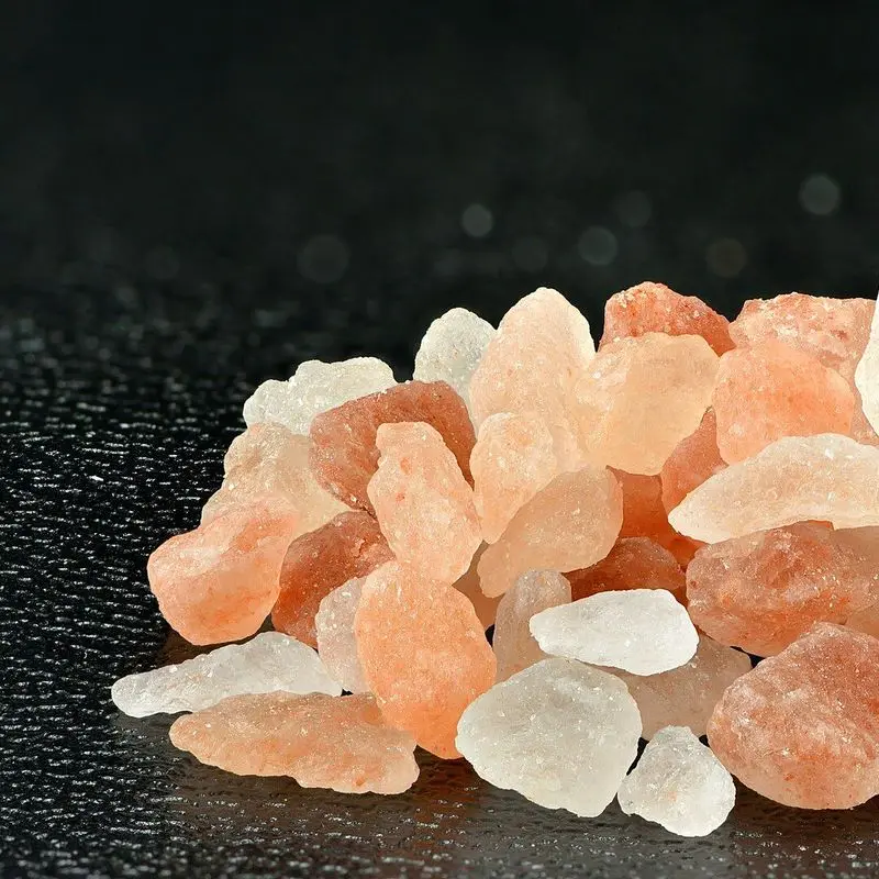 Montón de cristales de sal rosa del Himalaya gruesa sobre fondo oscuro