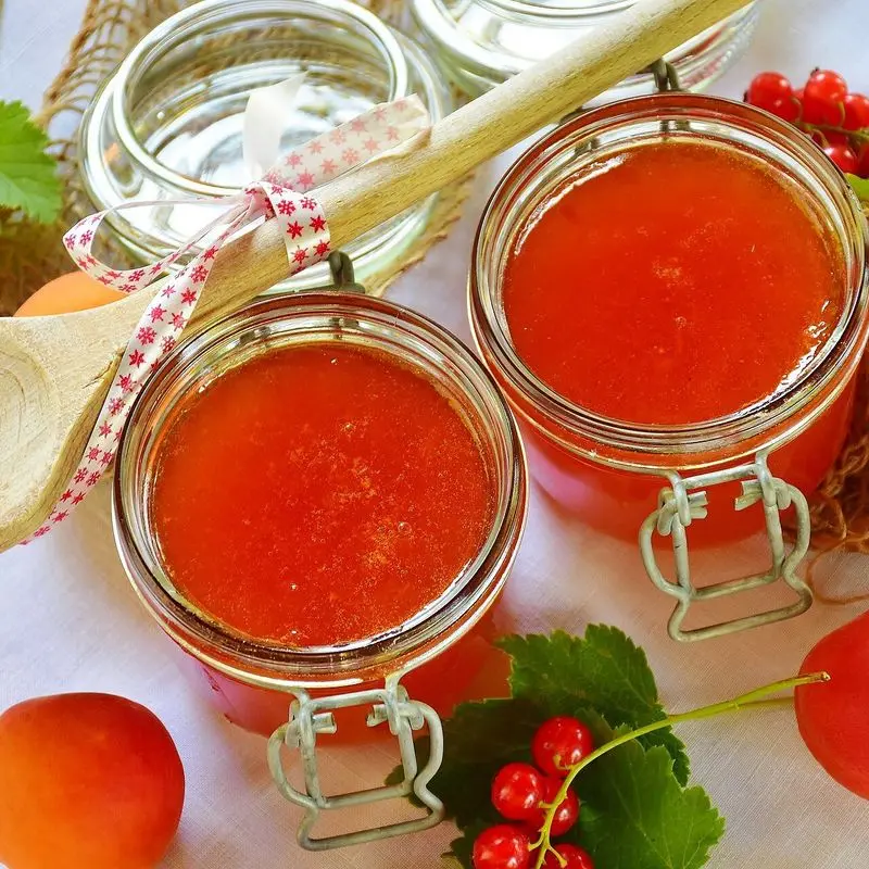Tarros de cristal con mermelada de albaricoque y albaricoques frescos