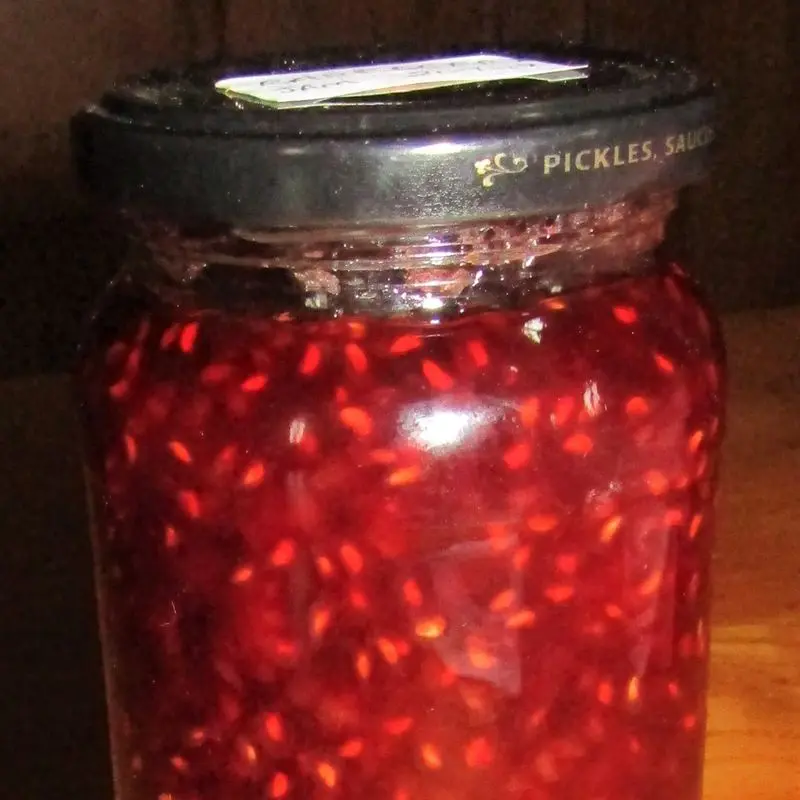 Tarro de cristal con mermelada casera de frambuesa con sus pepitas