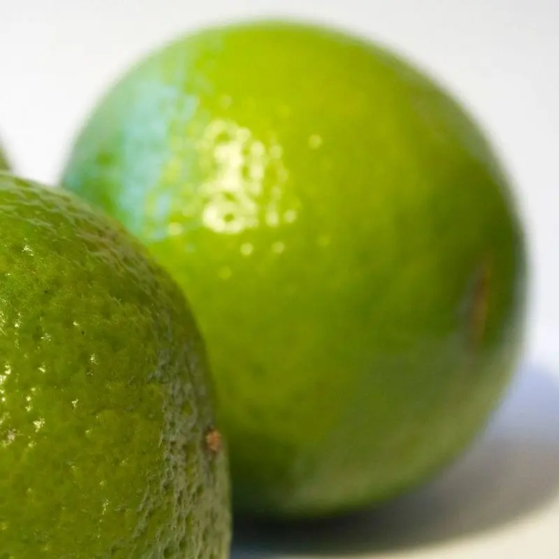 Tres limas verdes enteras sobre fondo blanco
