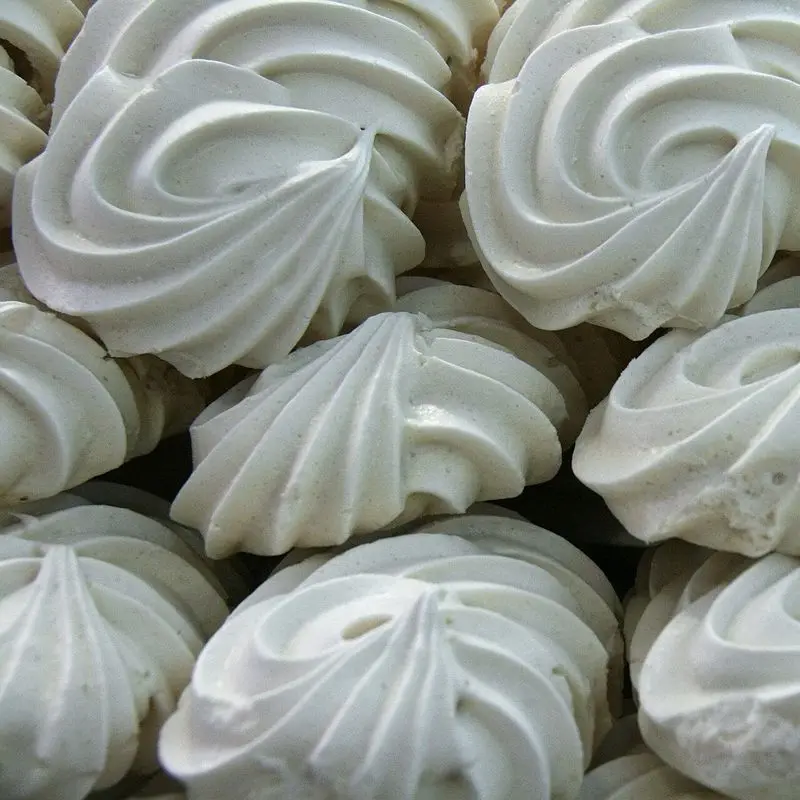 Merengues blancos con forma de espiral apilados en primer plano