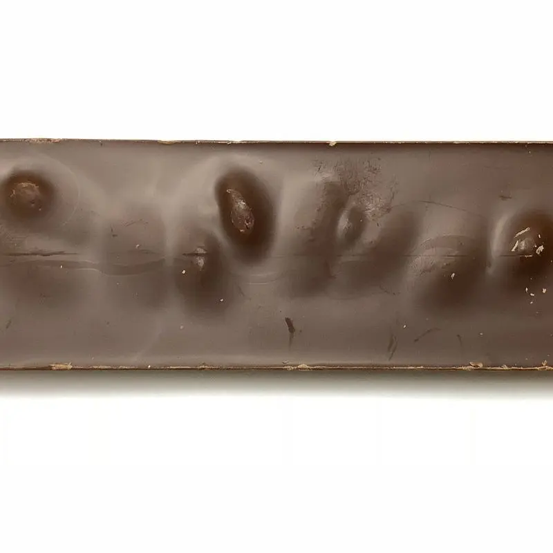 Tableta de chocolate con leche con almendras visibles en el reverso sobre fondo blanco