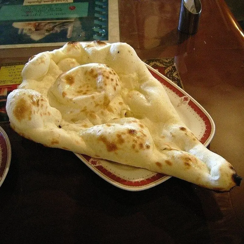 Pan naan hinchado y dorado sobre un plato