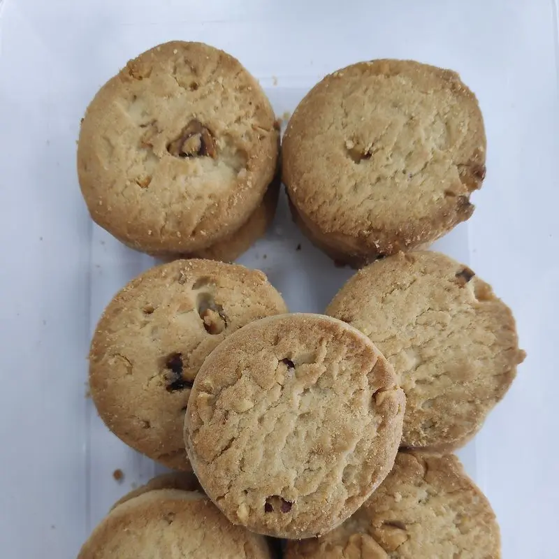 Montón de galletas redondas con trocitos de avellana sobre una superficie clara