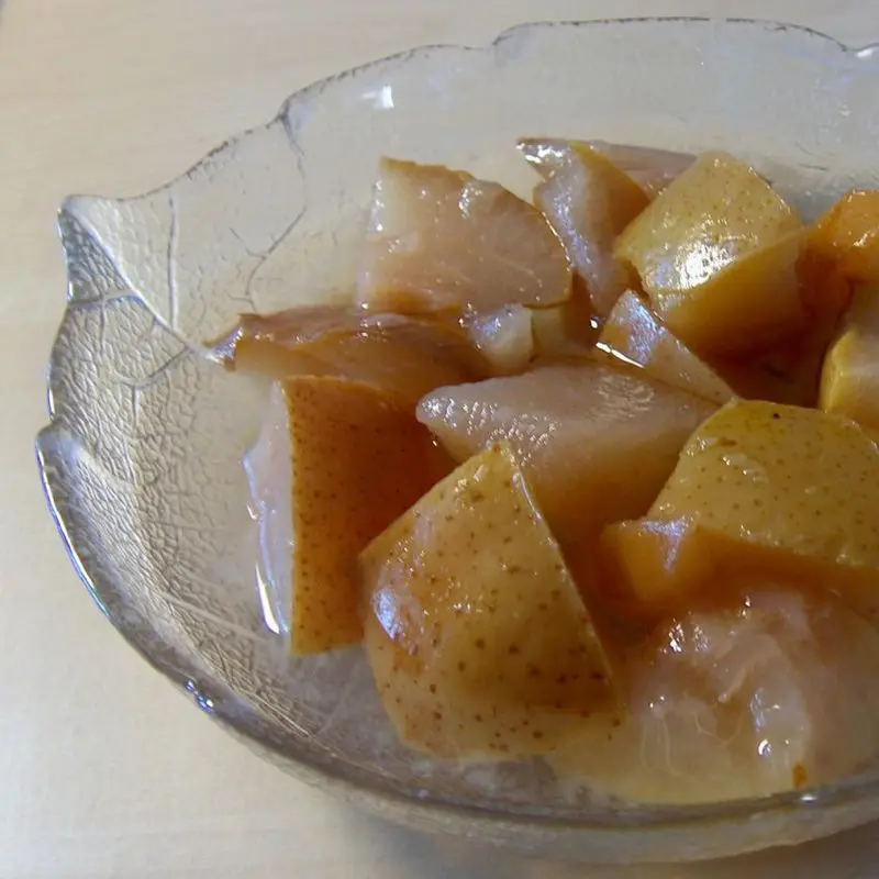 Cuenco de cristal con trozos de pera en almíbar