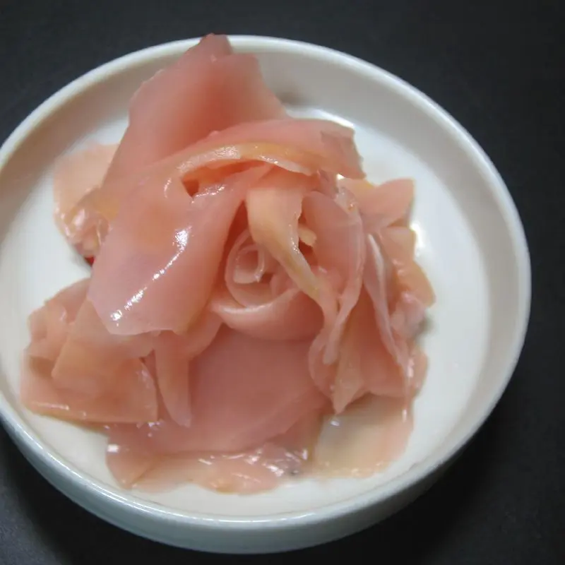 Cuenco blanco con jengibre encurtido rosado para sushi, en láminas finas