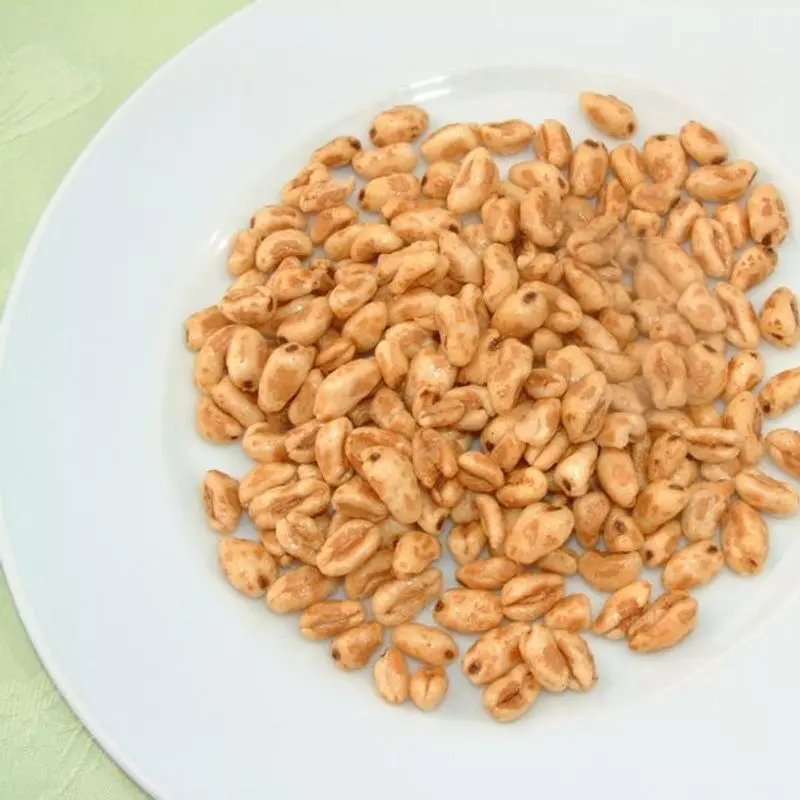 Granos de trigo inflado sobre un plato blanco