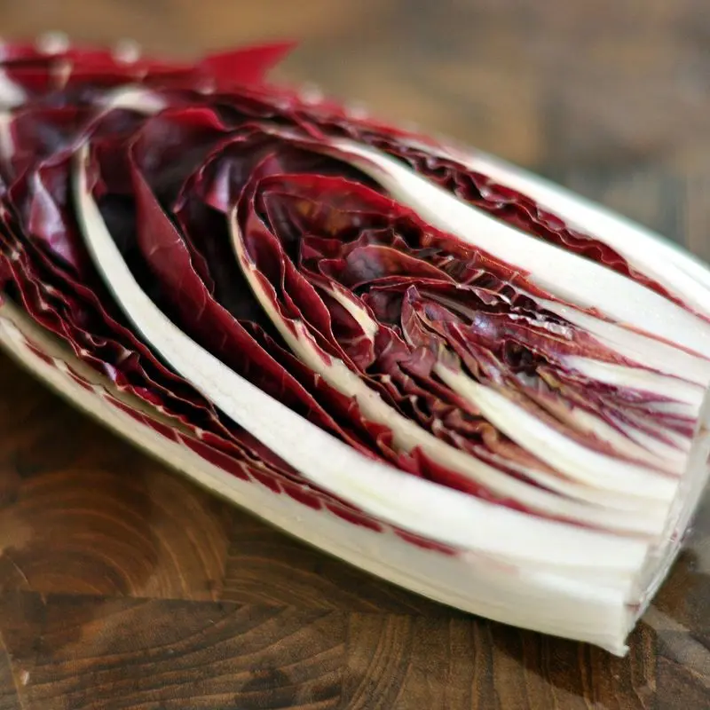 Cogollo de radicchio morado y blanco sobre una tabla de madera