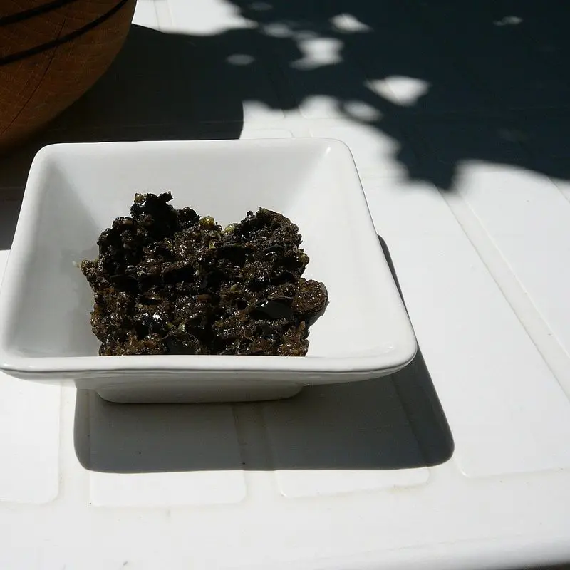 Cuenco blanco cuadrado con paté de aceitunas negras (tapenade)