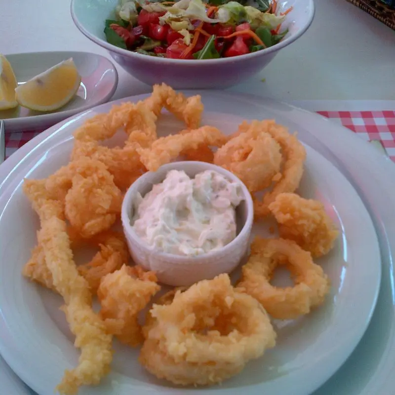 Cuenco con salsa tártara rodeado de anillas de calamar rebozadas