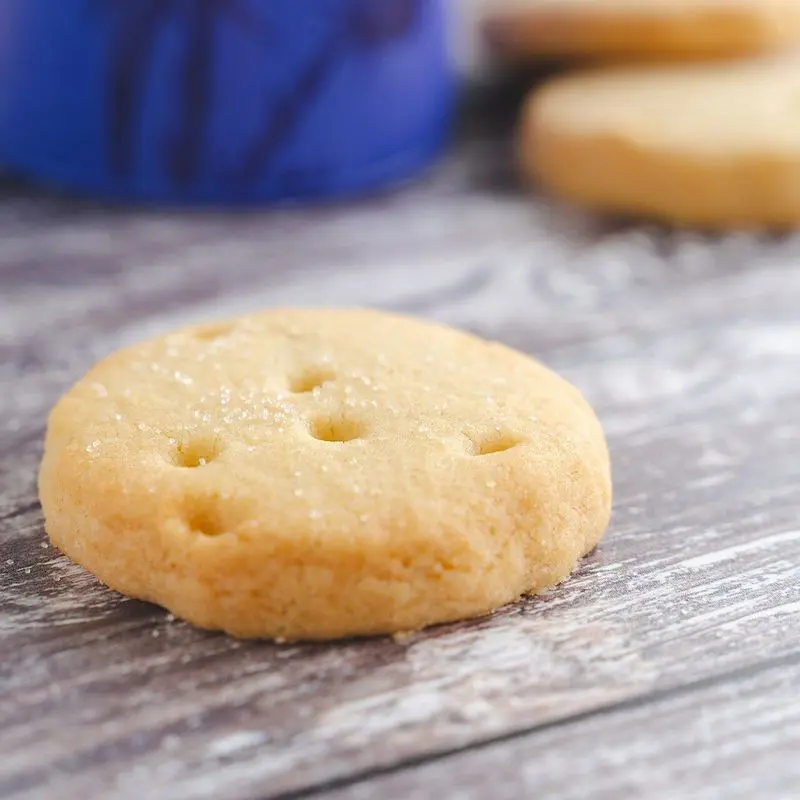Galleta redonda de mantequilla tipo pasta de té sobre una mesa de madera gris