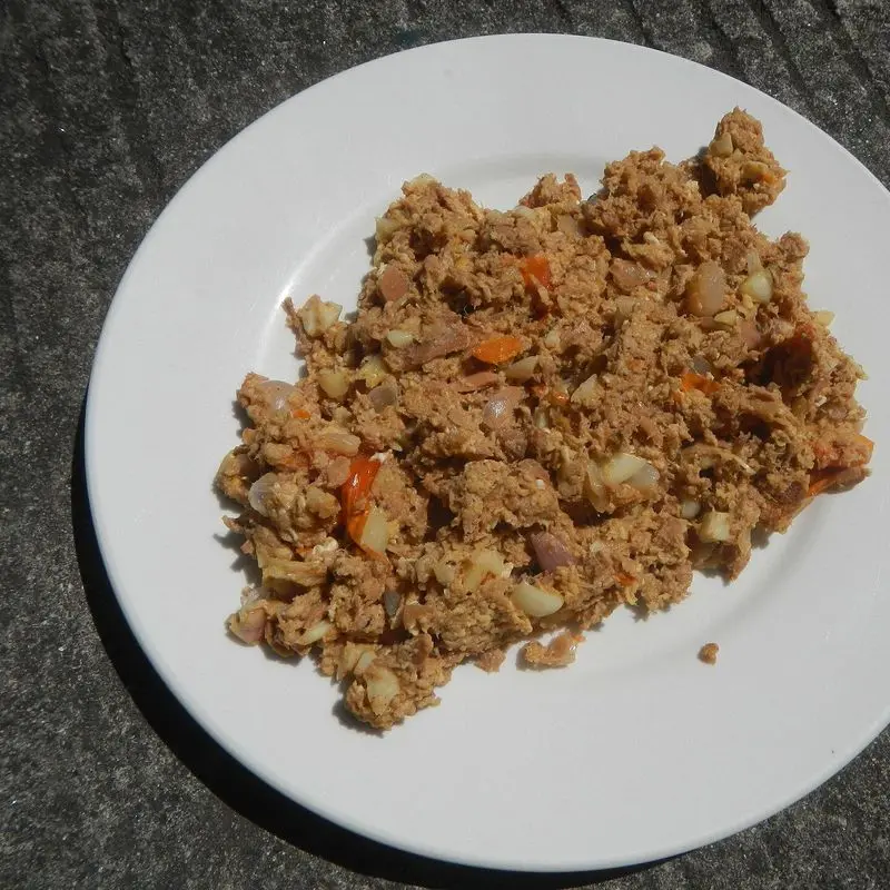 Atún en lata desmenuzado sobre un plato blanco