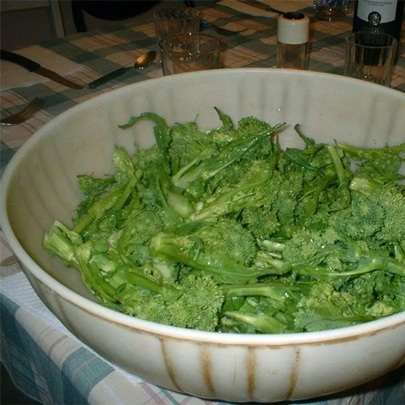 Fuente blanca llena de grelos (cime di rapa) verdes y troceados