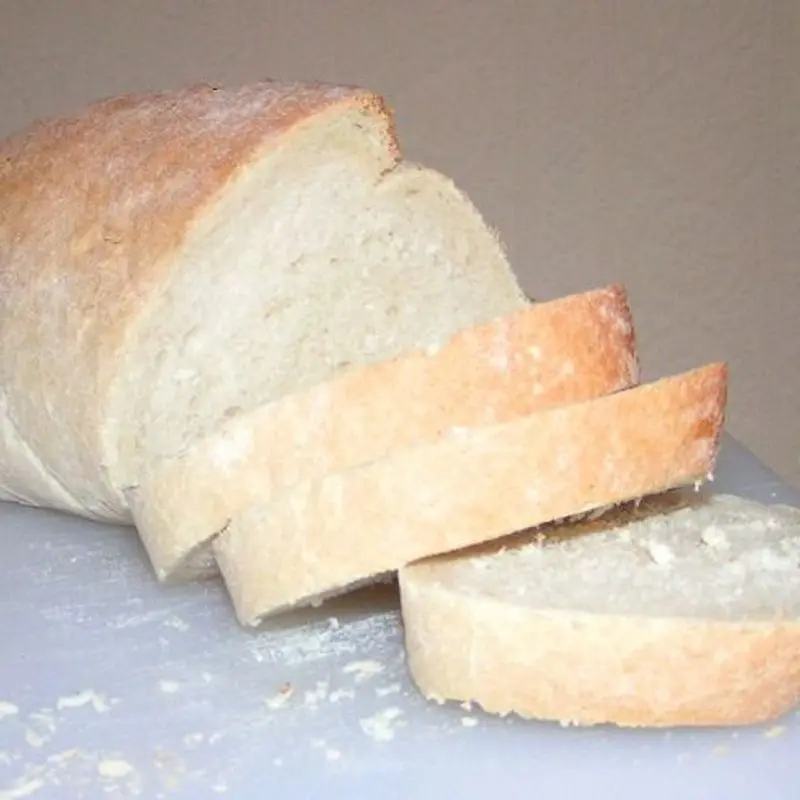 Hogaza de pan blanco con varias rebanadas cortadas