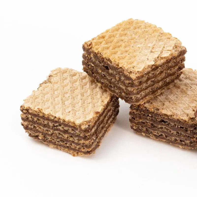 Obleas rectangulares de barquillo con relleno de crema apiladas sobre fondo blanco