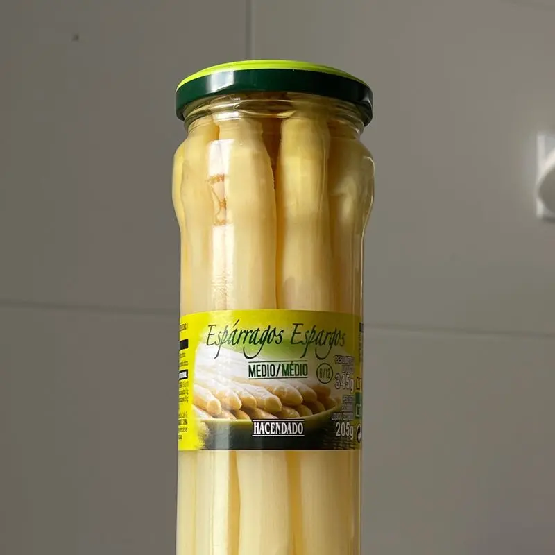 Tarro de cristal con espárragos blancos enteros en conserva y su etiqueta