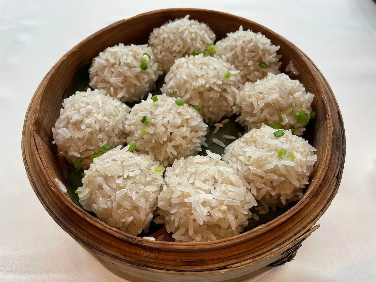 Cesta de bambú con albóndigas de cerdo cubiertas de arroz glutinoso cocidas al vapor
