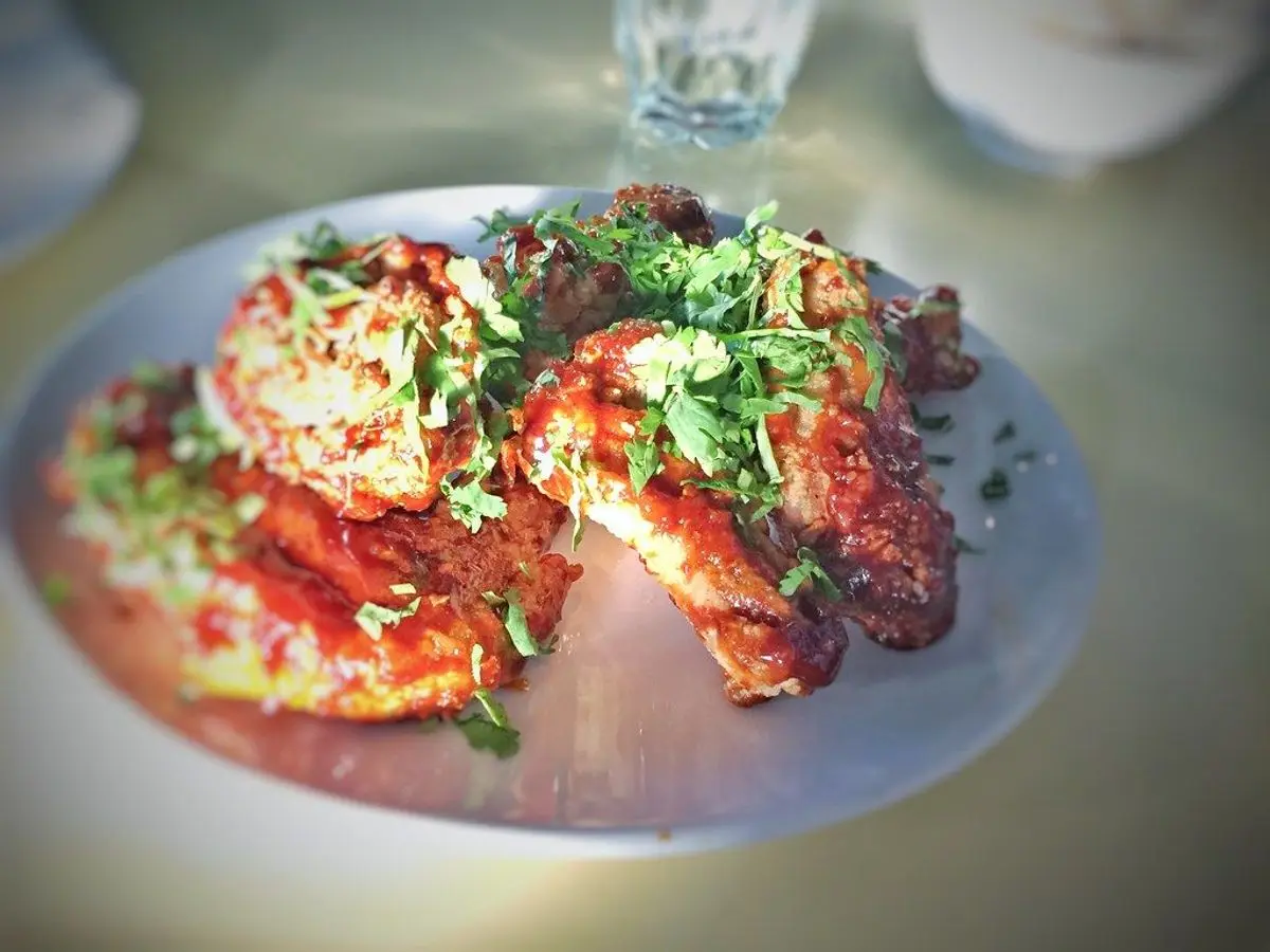 Alitas de pollo glaseadas con cilantro y cebolleta sobre un plato