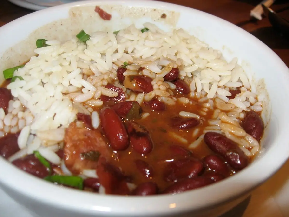 Cuenco blanco de alubias rojas guisadas con arroz blanco y cebolleta picada por encima