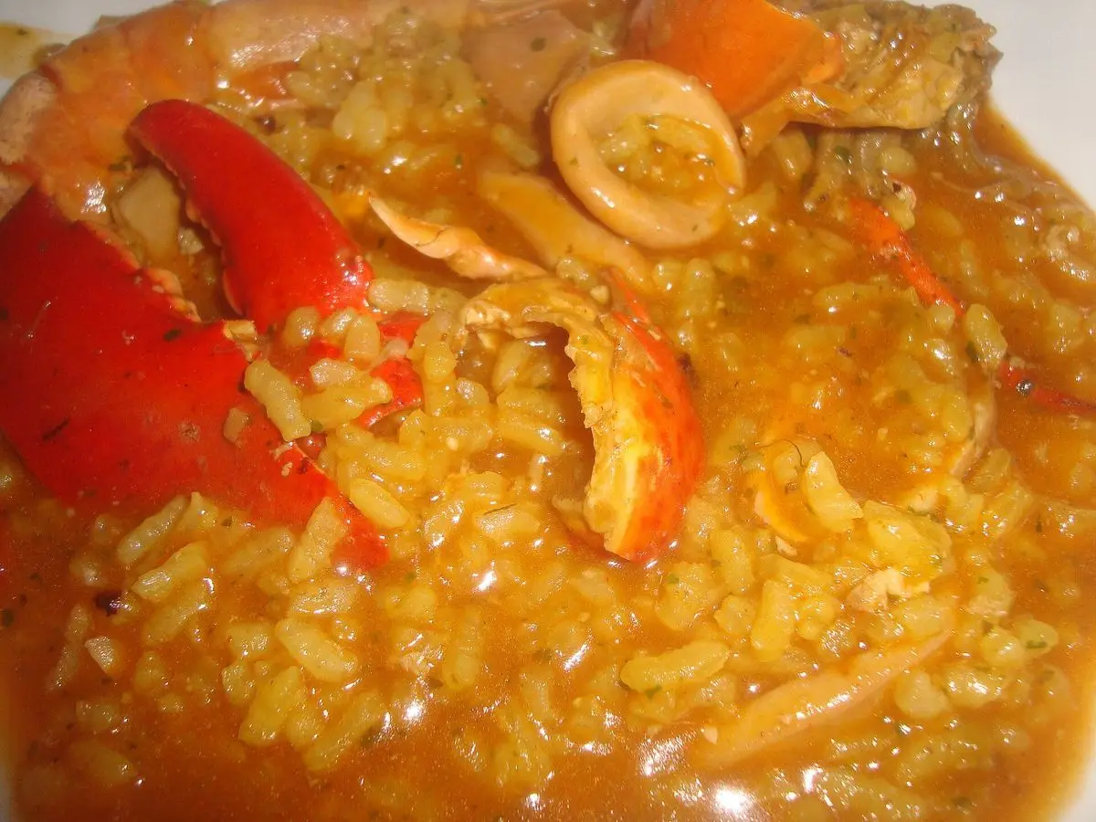 Arroz caldoso de marisco con pinzas rojas de bogavante y anillas de calamar en su caldo