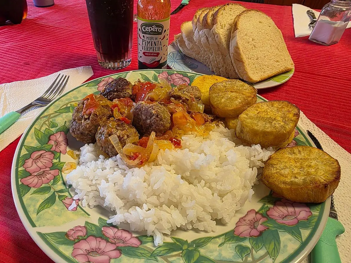 Plato con arroz blanco, albóndigas con verduras salteadas y patatas doradas