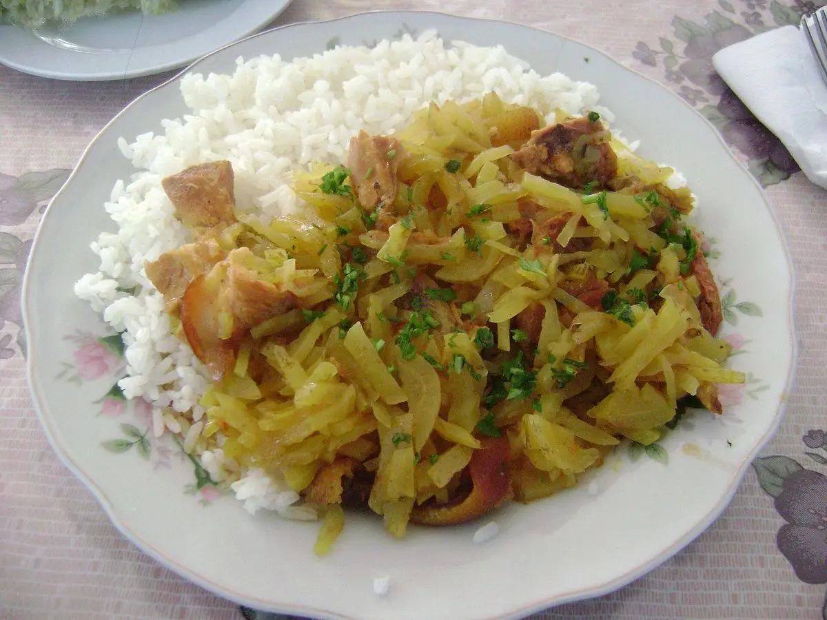 Plato con arroz blanco y guiso de carne de cerdo con verduras y perejil