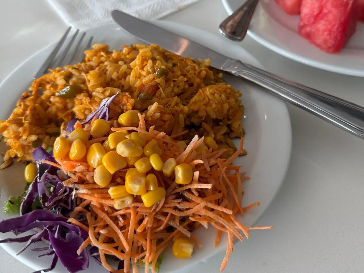 Arroz con pollo acompañado de ensalada de maíz, zanahoria y col lombarda