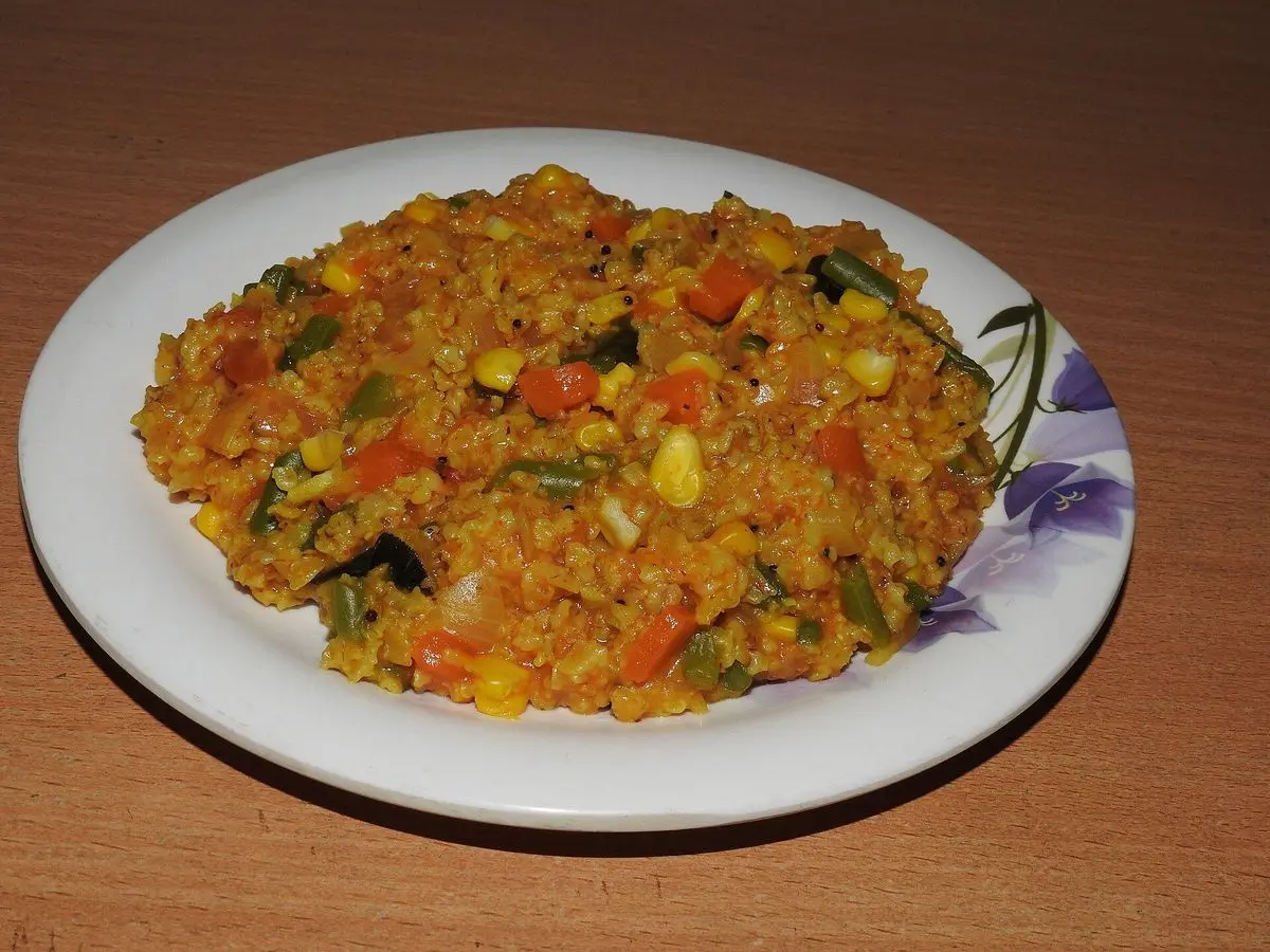 Plato de avena salada especiada con verduras en dados, tomate y maíz