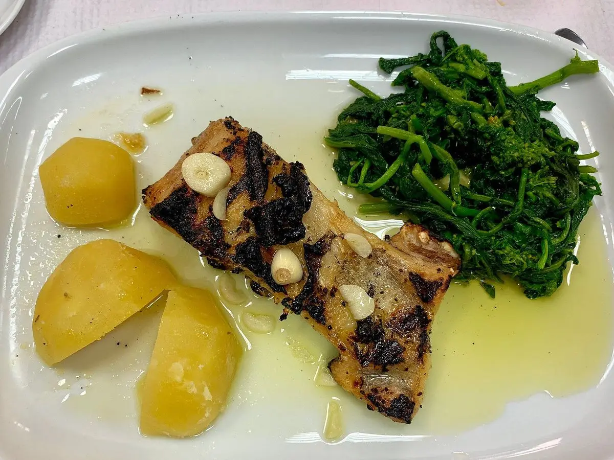 Lomo de bacalao con láminas de ajo, patatas cocidas y verdura salteada bañados en aceite de oliva