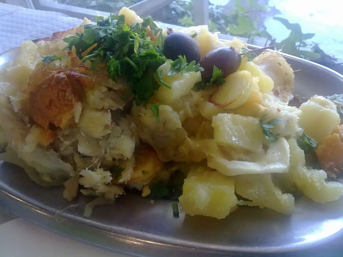 Bacalao a la Gomes de Sá con patata troceada, aceitunas negras y perejil