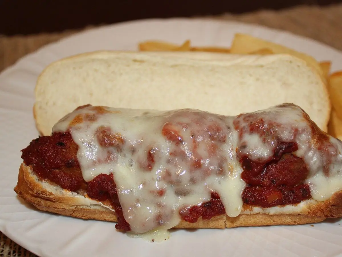 Bocadillo de albóndigas con tomate y queso fundido gratinado en un plato